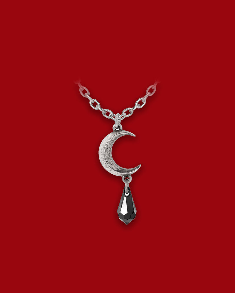 A gothic-chic pendant featuring a finely cast pewter crescent moon paired with a dangling black Austrian crystal teardrop, this necklace evokes the mystique of lunar tides and emotion-laden night. The crescent shape symbolizes intuitive cycles and hidden strength, while the polished pewter and shimmering crystal combine to create a dark elegance designed for both everyday wear and statement styling.