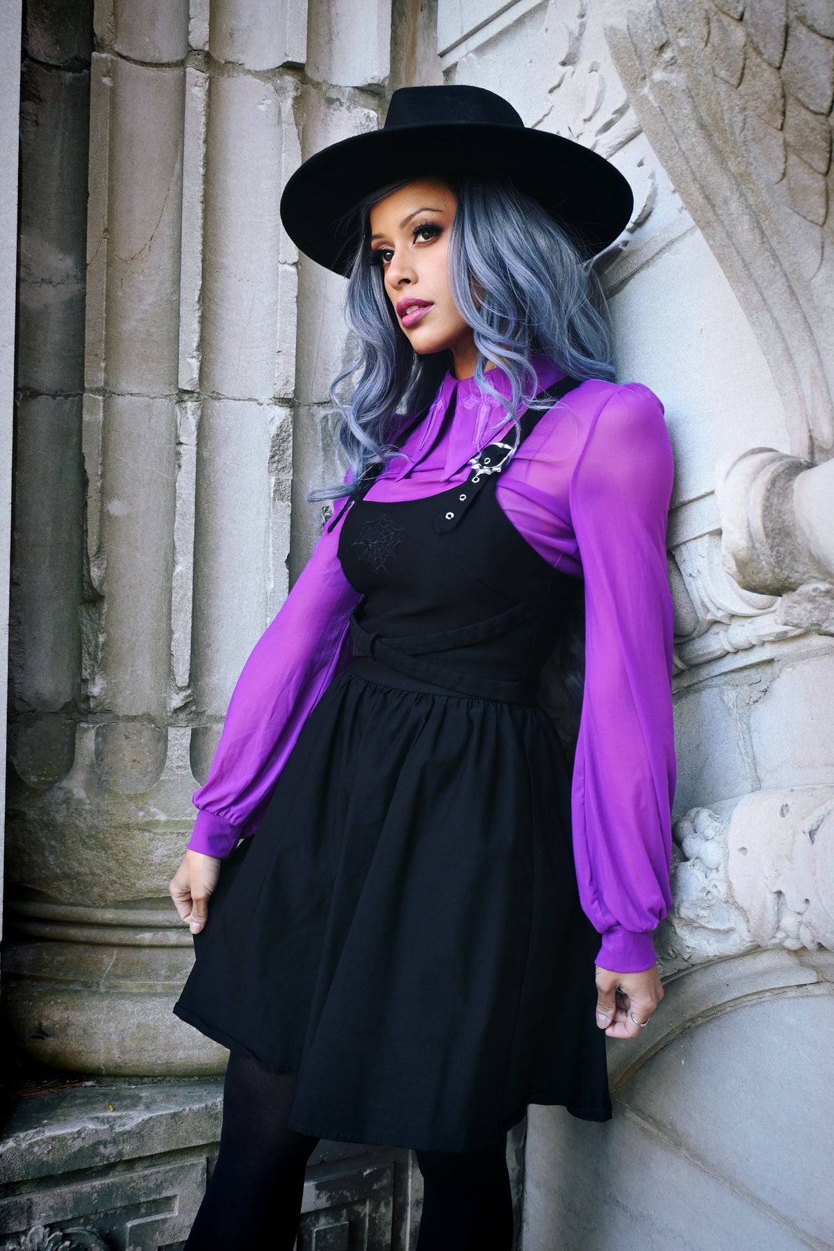 Elegant yet bold gothic-inspired mesh top made from soft see-through material, featuring long sleeves, oversized cross embroidery on a dramatic pointy collar, a small back keyhole cut-out, and available in black, white, and purple, perfect for alternative fashion, clubwear, or statement layering pieces.