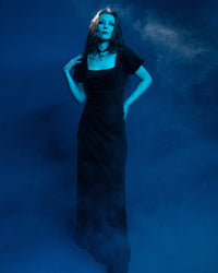 Elegant black Regency dress made of soft, stretchy velvet burnout fabric, designed with a flattering empire waist that elongates the silhouette. The puffed sleeves lend a vintage Victorian charm, while the scoop neckline enhances the neckline with a subtle romantic appeal. Combining gothic elegance with modern comfort, this dress is ideal for special occasions, gothic fashion, or those inspired by historical aesthetics.