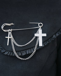 Silver oversized safety pin with dual cross charms and layered chain design. At 2.6 inches, this unique gothic-inspired accessory offers a sharp twist on classic jewelry, perfect for adding edgy sophistication to jackets, shirts, or handbags.