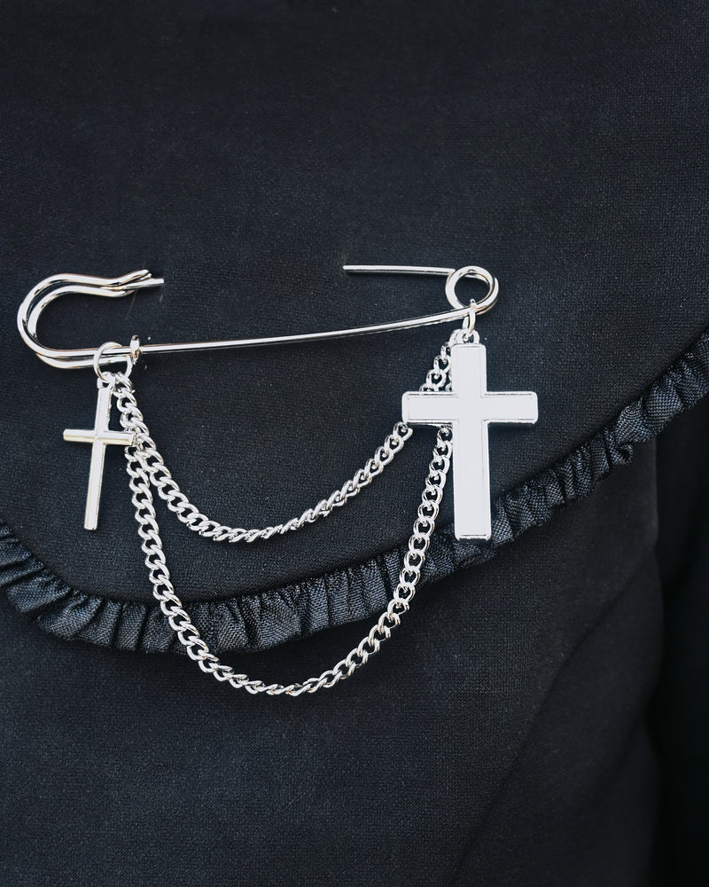 Silver oversized safety pin with dual cross charms and layered chain design. At 2.6 inches, this unique gothic-inspired accessory offers a sharp twist on classic jewelry, perfect for adding edgy sophistication to jackets, shirts, or handbags.