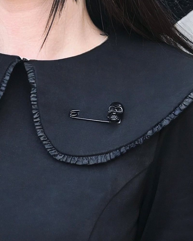 Gothic matte black skull brooch in a classic safety pin design with subtle shine. This 2-inch accessory offers a dark, stylish twist to everyday outfits, adding character and attitude to jackets, shirts, or handbags.