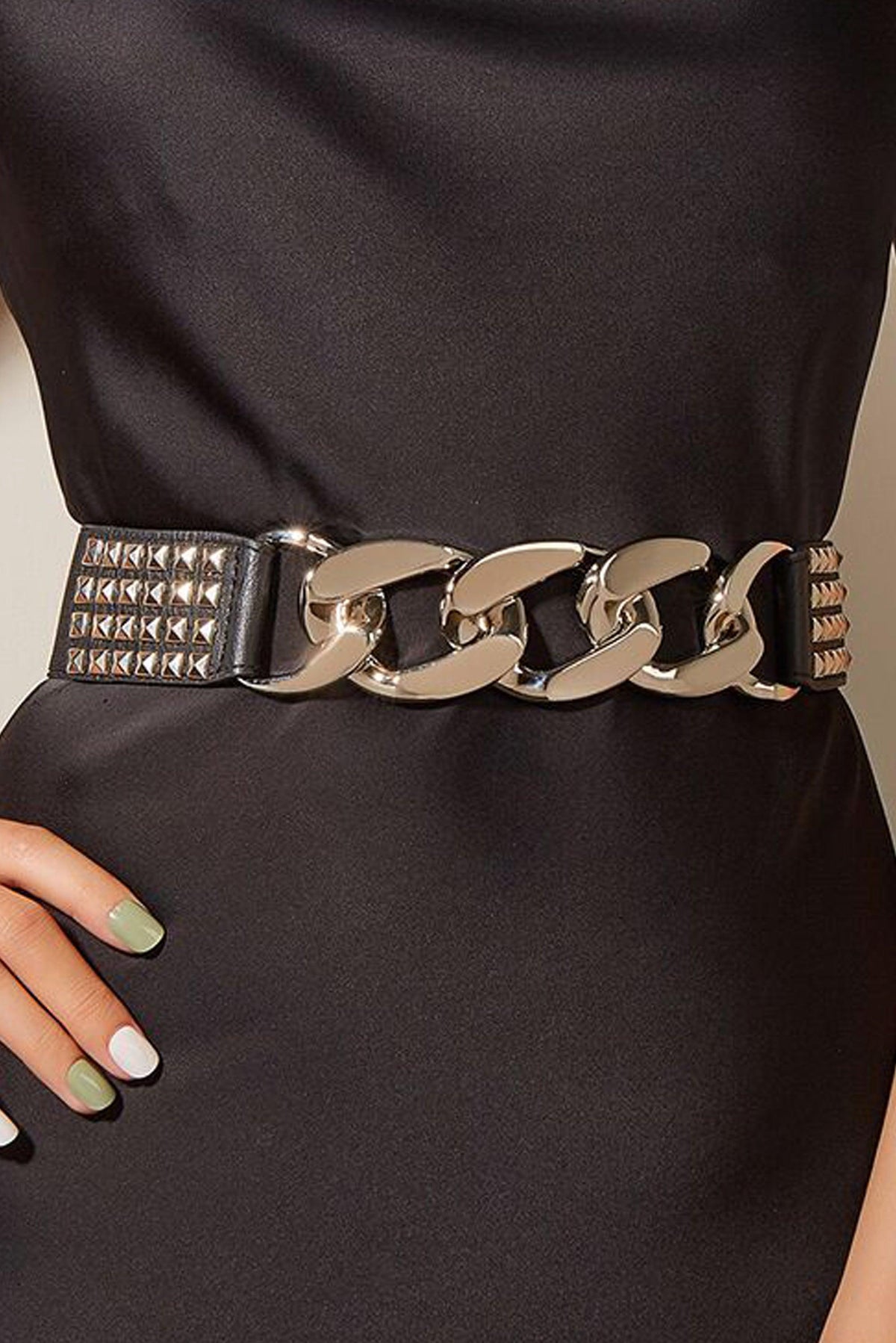 Fashion-forward black elastic belt adorned with chunky silver chains and metallic pyramid studs, offering a snug fit and versatile styling for casual outfits, dresses, or layered streetwear looks.
