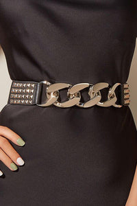 Fashion-forward black elastic belt adorned with chunky silver chains and metallic pyramid studs, offering a snug fit and versatile styling for casual outfits, dresses, or layered streetwear looks.