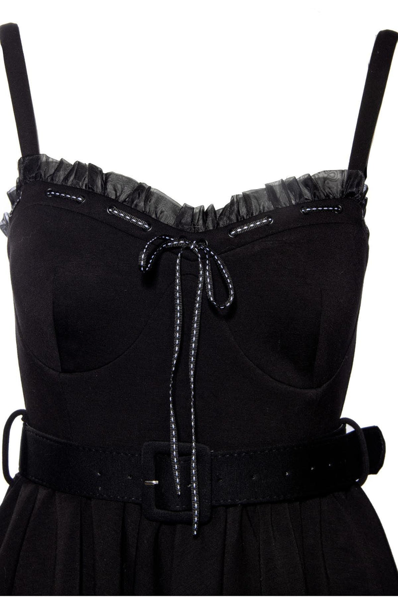 Classic fit-and-flare Love Bites Swing Dress in luxurious black poly blend, featuring a sweetheart bustline enhanced with ruffles and a ribbon bow, enlarged cup sizing for all-day comfort, functional side seam pockets, adjustable straps for a custom fit, and ruched back details, designed by Jessica Louise to combine playful elegance with practical wearability for any fashionable occasion.