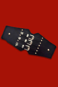 Triple Buckle Belt in black vegan leather featuring three parallel silver buckles and a stretchy back panel for a comfortable fit. Perfect for gothic, alternative, or edgy street-style outfits, ideal for cinching dresses, coats, or oversized shirts.