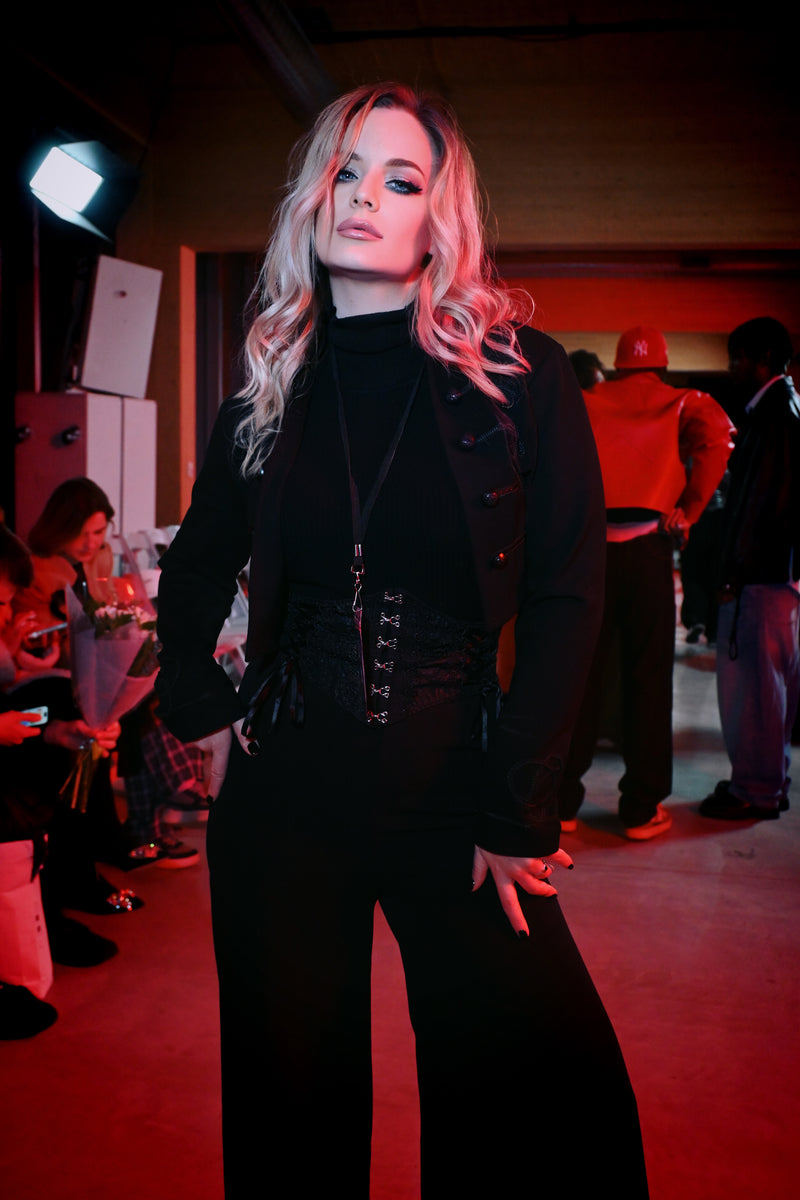 A luxurious women’s cropped jacket inspired by Victorian military uniforms, featuring intricate braided trim, detailed ouroboros-embossed buttons, and a high mandarin collar. Crafted from a structured yet stretchy ponte fabric, this black gothic jacket offers a tailored silhouette that enhances the waist while providing comfort and versatility for layering in dark alternative fashion.