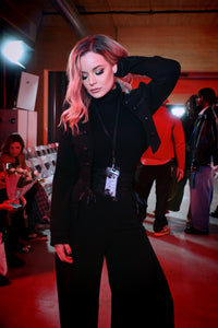 A tailored gothic black jacket with strong Victorian military aesthetics, made from stretch ponte for structure and movement. It showcases ornamental braided trims, symbolic ouroboros buttons, and a striking mandarin collar. The cropped open-front cut gives it a sophisticated shape, perfect for adding drama to gothic, steampunk, or alternative fashion outfits.
