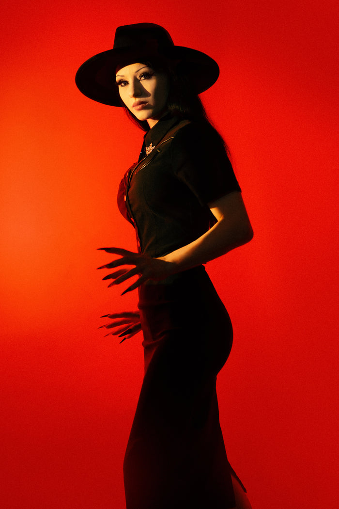 The Wanda Pencil Dress is a timeless black dress designed to accentuate every curve, crafted from high-quality Bengaline fabric that provides exceptional comfort, flexibility, and a flattering, body-sculpting fit. Featuring upgraded functional snaps instead of buttons, sleek pleather piping, and removable silver collar clips, this classic pencil dress offers a unique blend of modern sophistication and subtle Western-inspired elegance for any season.