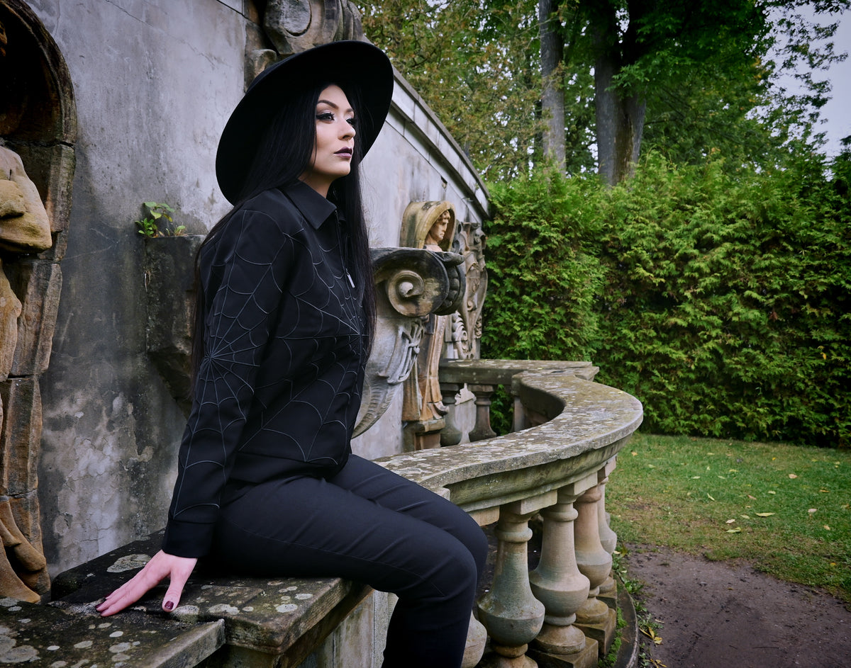 Tonal-black 1950s-inspired work jacket with intricate black web embroidery at key points (front, back, sleeves), two zippered pockets along the side seams and a hidden interior pocket for extra storage, an ideal layering piece for mild-weather seasons.