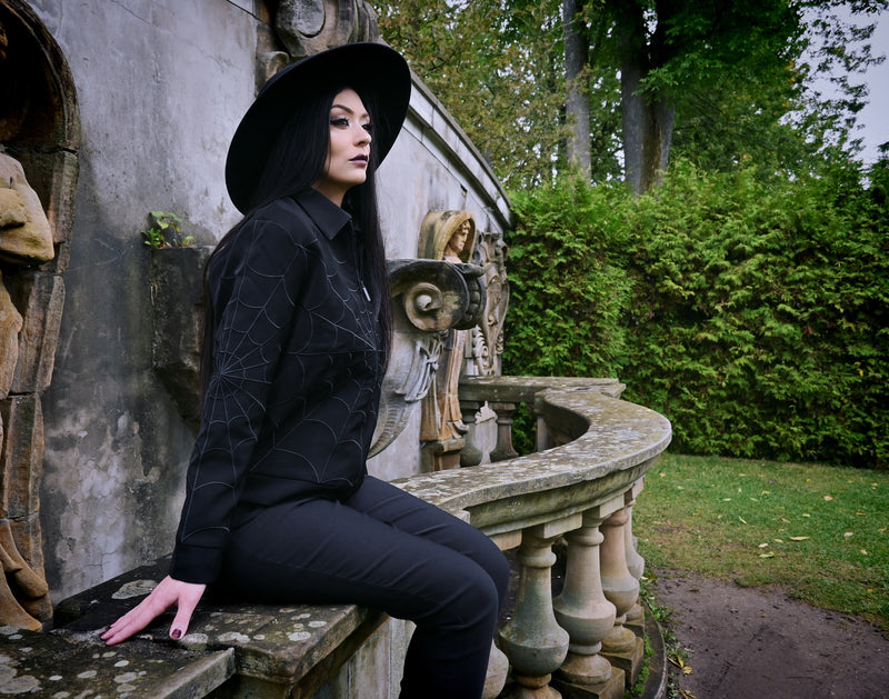 Tonal-black 1950s-inspired work jacket with intricate black web embroidery at key points (front, back, sleeves), two zippered pockets along the side seams and a hidden interior pocket for extra storage, an ideal layering piece for mild-weather seasons.