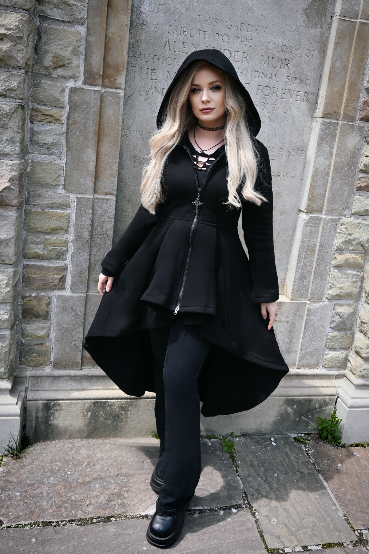 The long high-low hoodie combines cozy construction with dramatic gothic styling. Made from thick 400 GSM 100% cotton, it features a soft fleece lining for warmth, an oversized hood, and deep front pockets. Corset-style back lacing adds texture and shape to the silhouette, while the black front zipper is finished with a gothic cross-shaped pull for a distinctive alternative touch.
