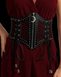 A gothic-inspired black corset belt combining synthetic leather, mesh panels, and silver-toned stud detailing. The Lunar Corset Belt features a functional center zipper with a crescent moon charm as a distinctive celestial accent. Side lacing finished with silver skull aglets adds dramatic detail, while the wide ruffled elastic stretch band at the back allows for comfortable wear and a cinched silhouette.