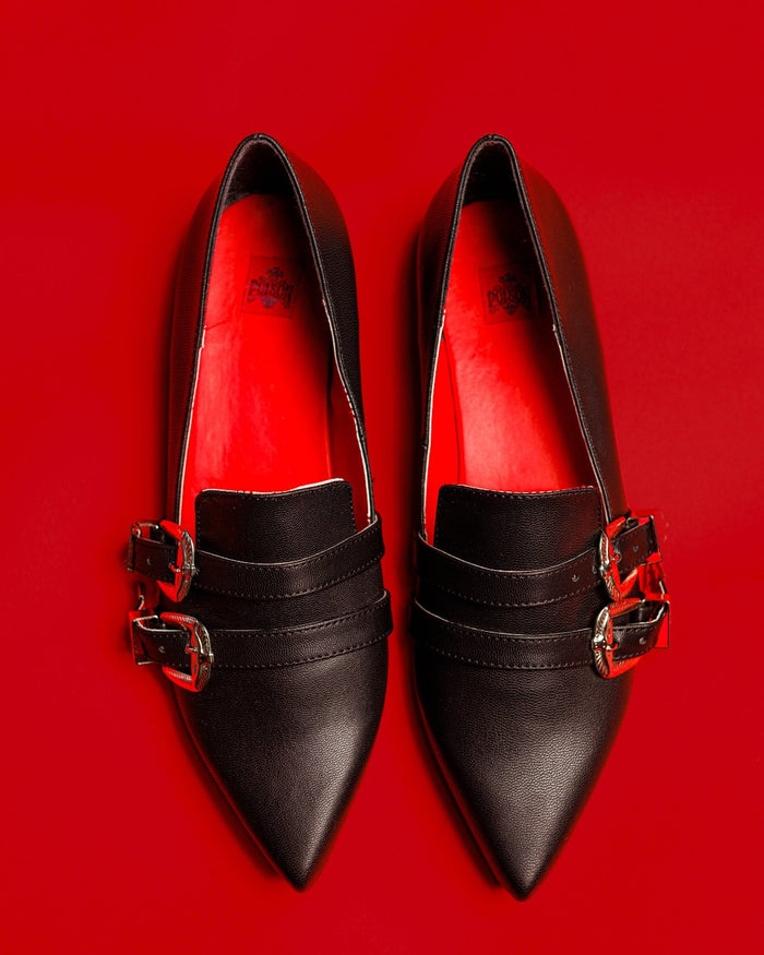 Top view of the Antonella flat shoes matte against a red background.