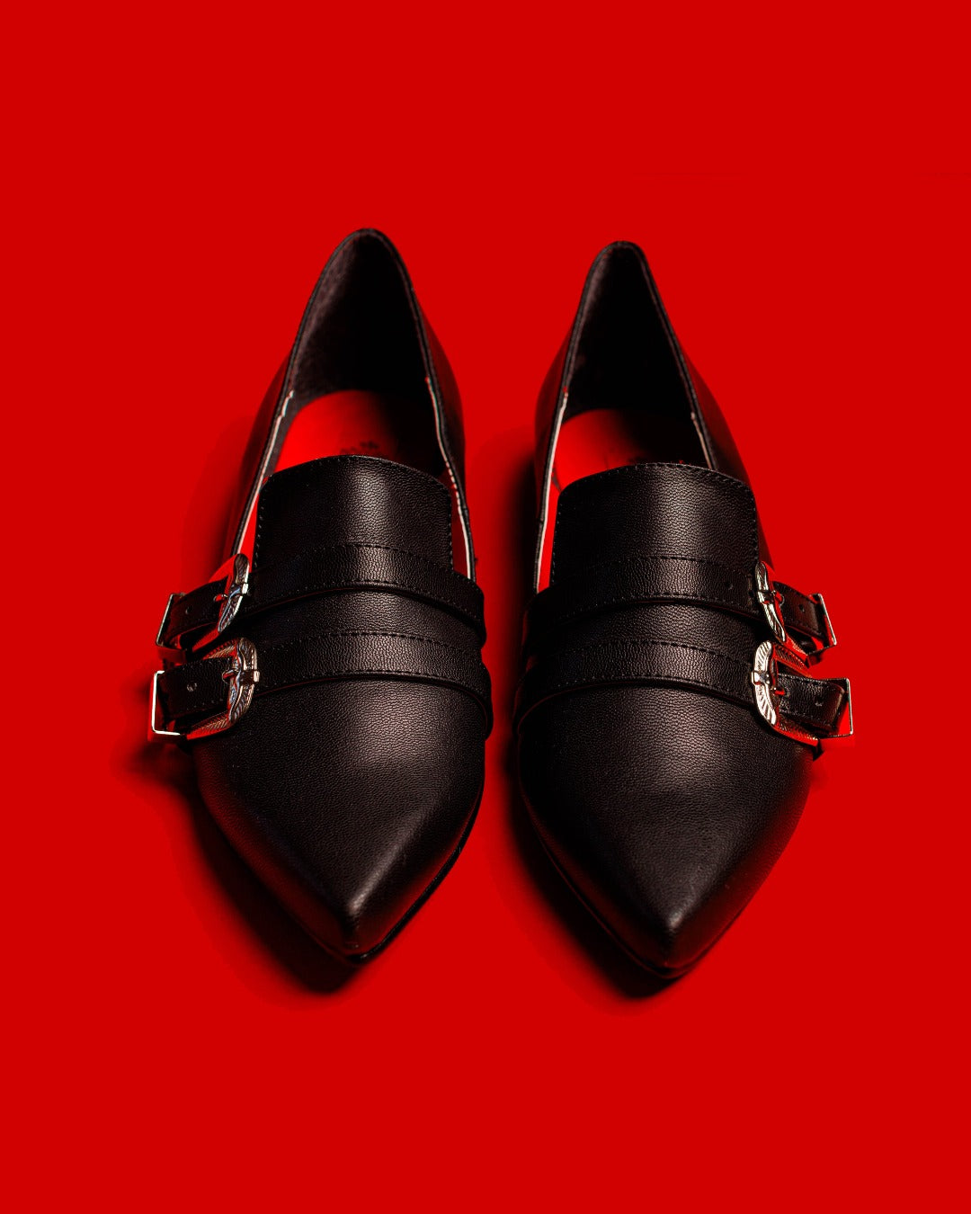 Front view of the Antonella flat shoes matte against a red background.