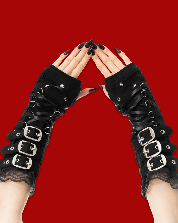 Black lace gloves with buckles on a red background