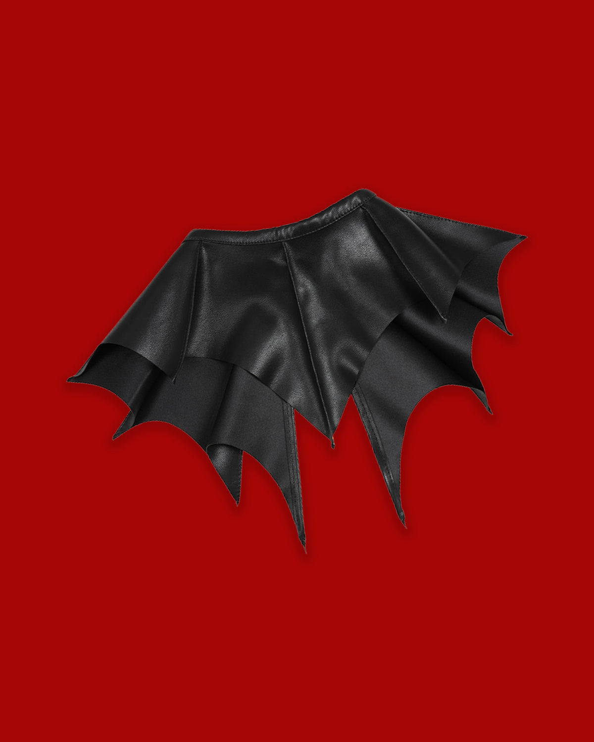 A dramatic black detachable collar featuring sharp, pointed batwing-inspired panels that extend across the shoulders for a distinctive gothic silhouette. The Nightwing Collar is designed as a versatile statement accessory that can be layered over everyday tops, dresses, knitwear, or jackets. Its theatrical shape adds dark-academic elegance to tailored outfits or creates a striking alternative look when styled with mesh, corsetry, and platforms.