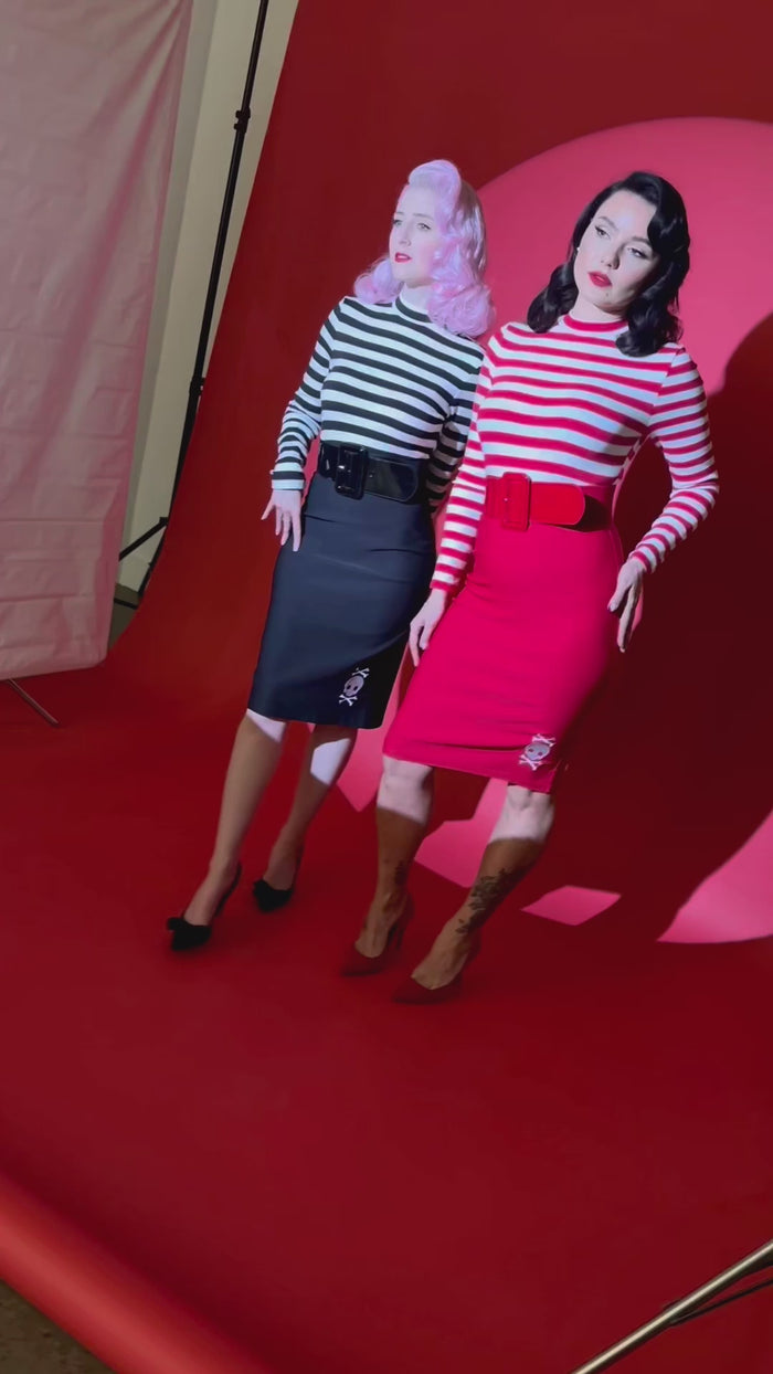 The Jailhouse Dress by Katakomb blends gothic edge with vintage allure, featuring a striped mock turtleneck top and stretchy bengaline skirt that flatters every curve, complete with intricate skull embroidery by Jessica Louise for a rebellious, rockabilly-inspired look available in bold black or striking red.