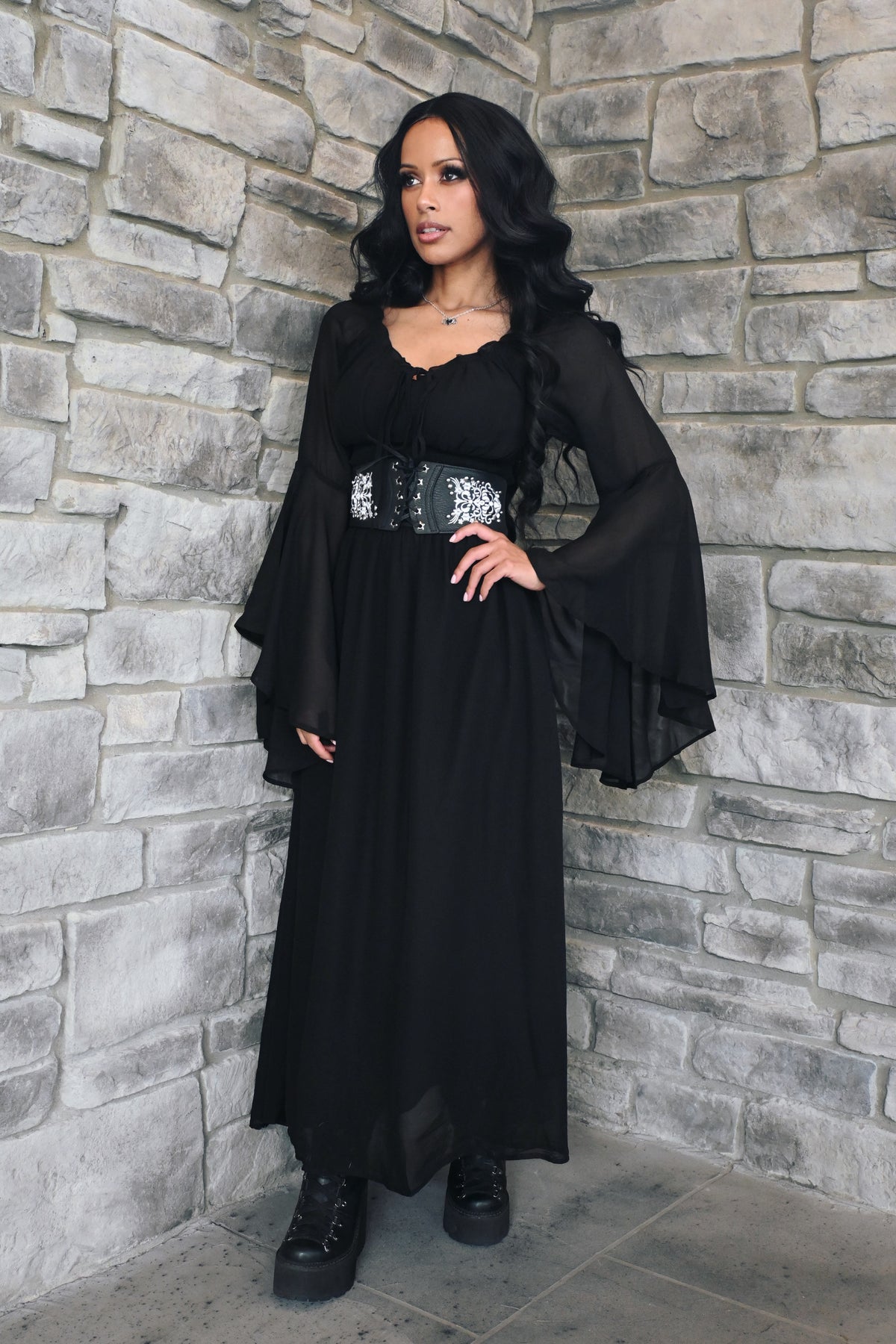 A women's Renaissance-inspired maxi dress featuring a graceful off-shoulder neckline, dramatic bell sleeves, and a comfortable smocked waist. The flowing maxi skirt creates an elegant silhouette and moves beautifully with the wearer. This versatile fantasy dress is ideal for Renaissance fairs, pirate festivals, cosplay, LARP events, garden weddings, music festivals, or styled with a corset belt and boots for a romantic alternative look.