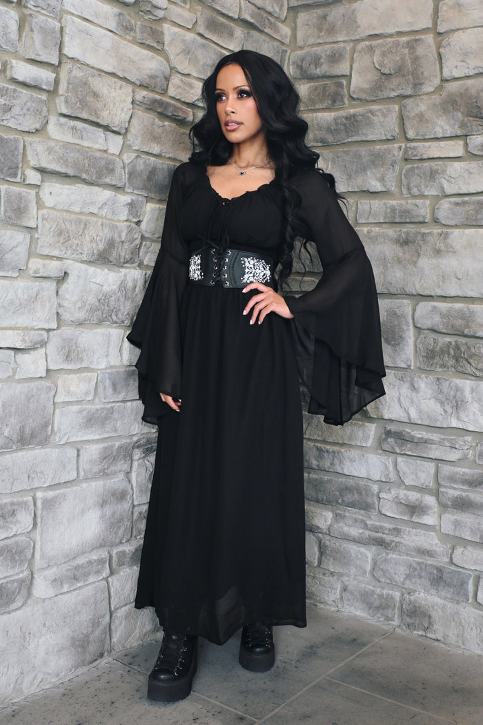A women's Renaissance-inspired maxi dress featuring a graceful off-shoulder neckline, dramatic bell sleeves, and a comfortable smocked waist. The flowing maxi skirt creates an elegant silhouette and moves beautifully with the wearer. This versatile fantasy dress is ideal for Renaissance fairs, pirate festivals, cosplay, LARP events, garden weddings, music festivals, or styled with a corset belt and boots for a romantic alternative look.