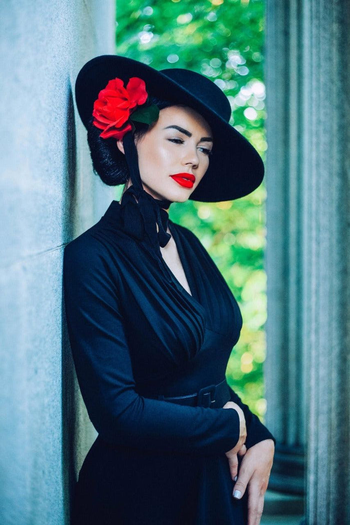 Handcrafted American Gothic wide-brimmed hat made from 100% wool, available in carbon black and fire-engine red. Features a romantic black ribbon accent, perfect for gothic, vintage-inspired, and alternative fashion outfits, adding timeless elegance to any look.