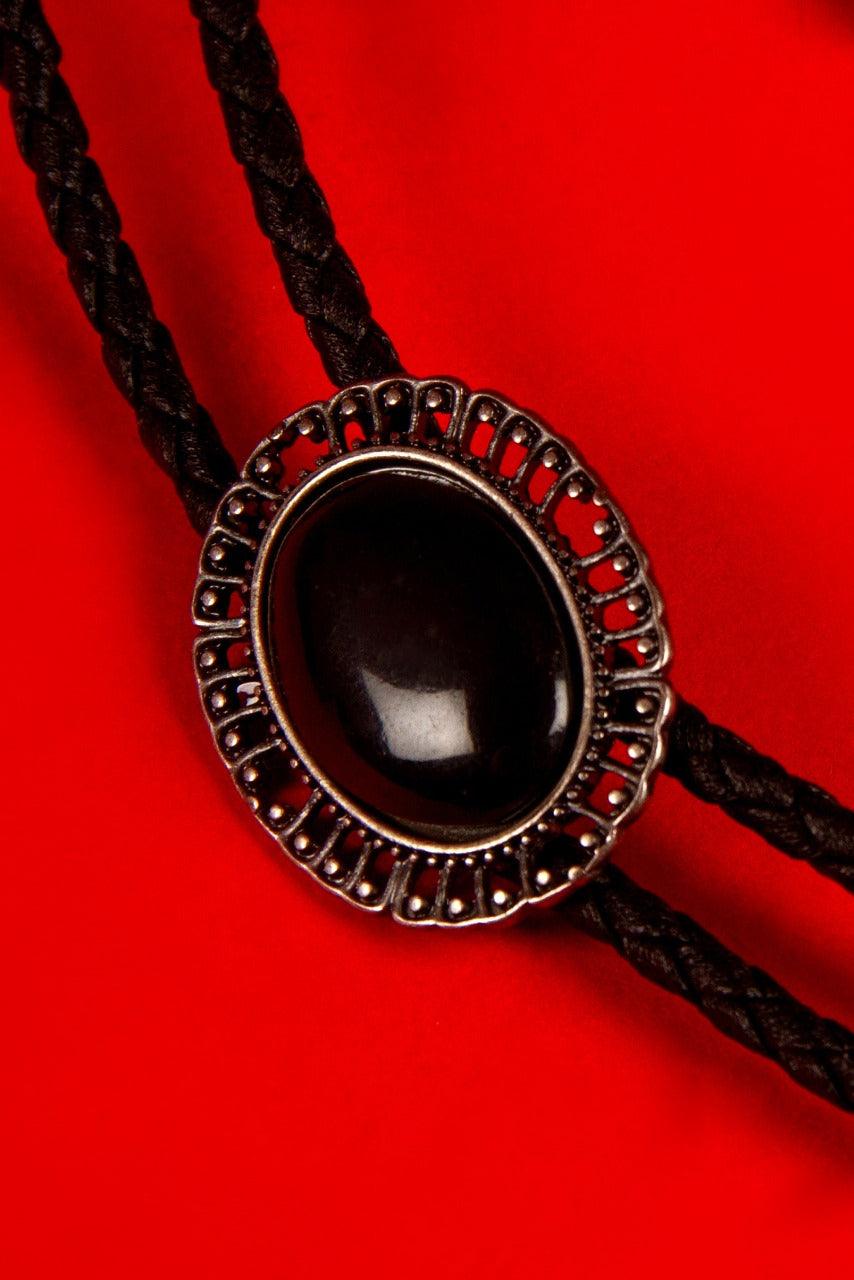 Fuse vintage western flair with gothic edge in this black bolo tie. Sleek, dark, and effortlessly stylish, it’s the perfect finishing piece for gothic wardrobes, steampunk ensembles, or refined evening wear with a shadowy twist.