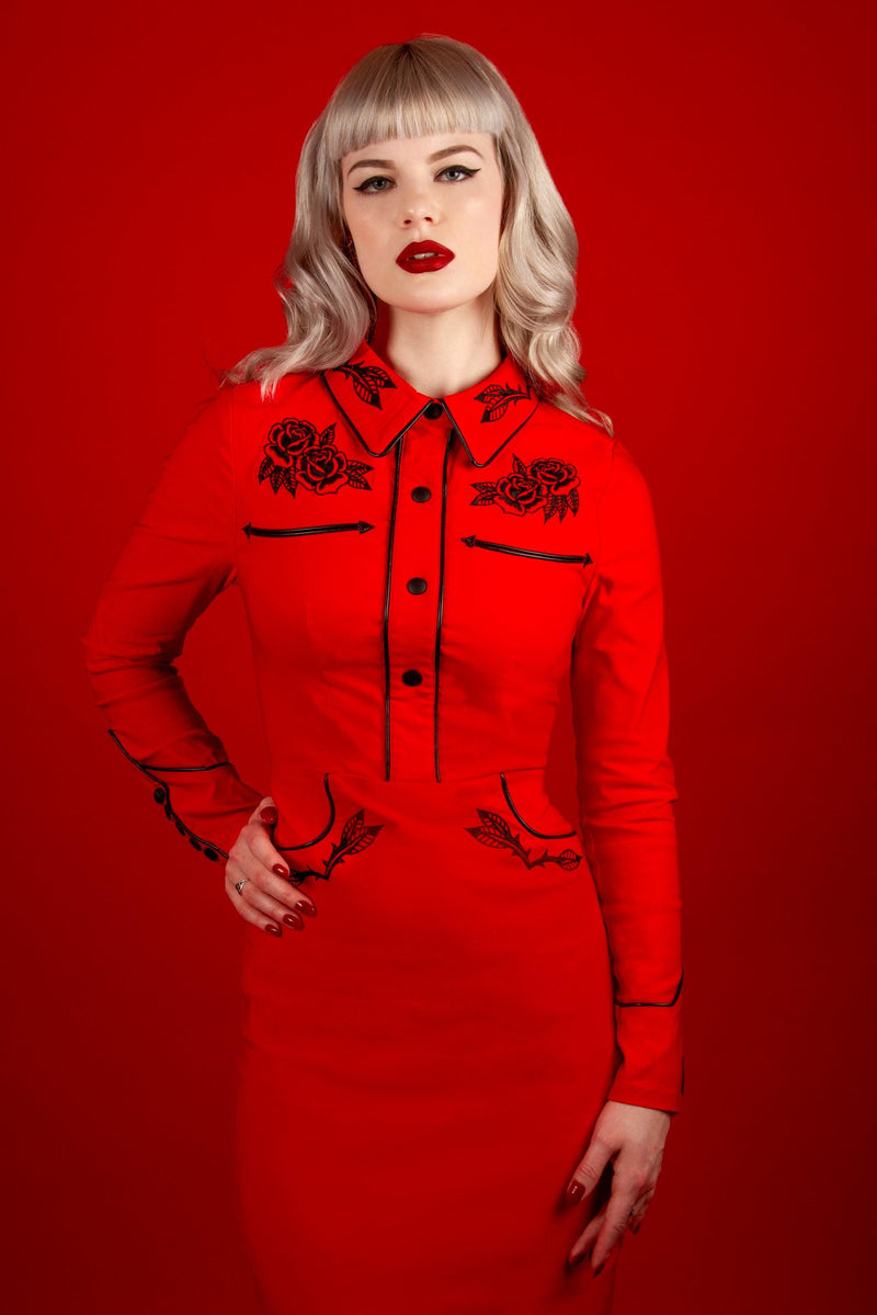 The June Dress in red merges the worlds of gothic western and vintage rockabilly fashion, offering intricate embroidery, polished pleather piping, and long piped sleeves. With its seamless fixed snaps and stretch bengaline construction, this dress provides both structure and flexibility for a uniquely elegant and rebellious aesthetic.