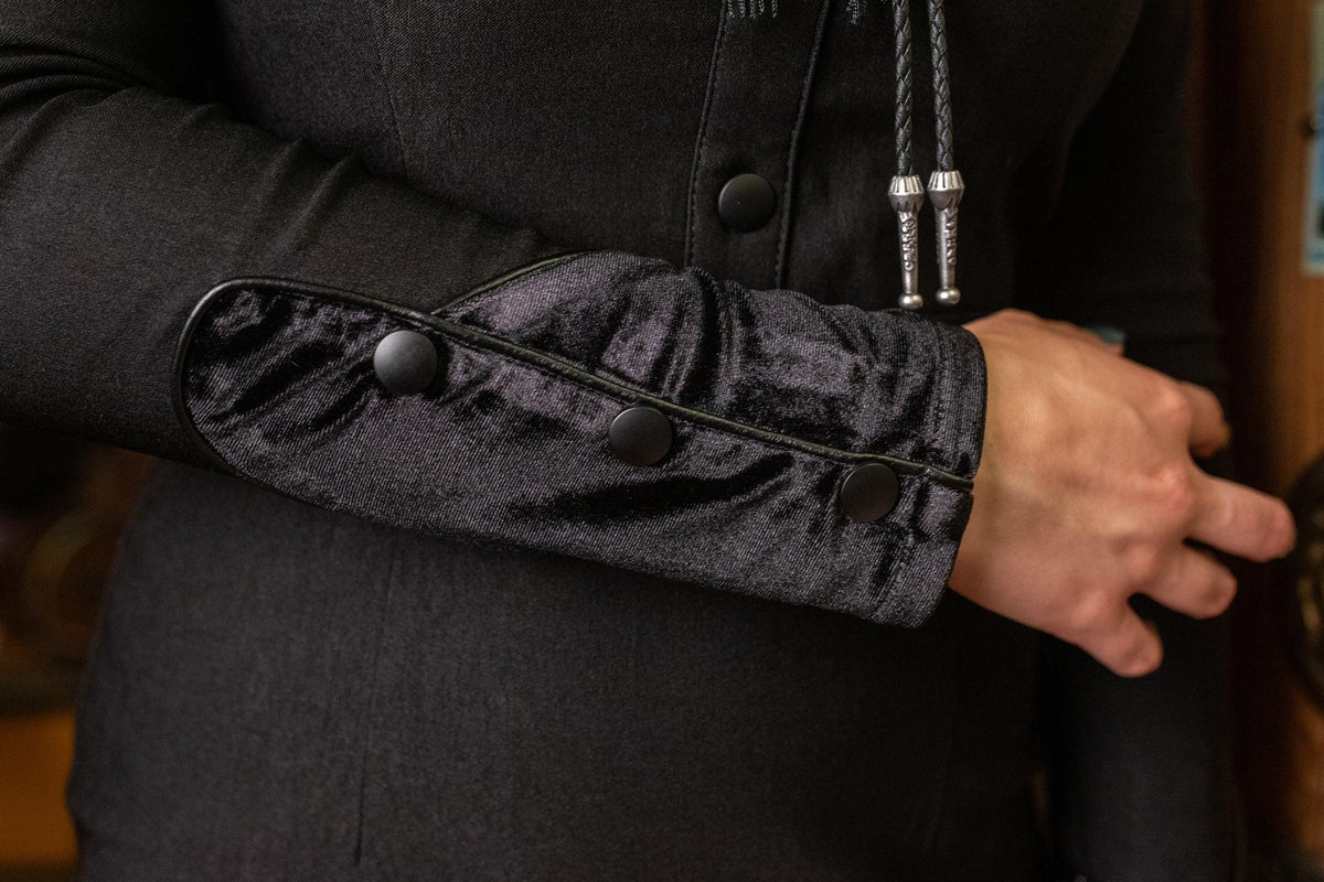 Featuring a cheeky fringe, timeless arrow design across the bust, pleather yoke accents, and elegant faux velvet panels, the black Loretta Dress combines Western-inspired design with contemporary fashion, all handmade from premium bengaline fabric for a flattering, comfortable, and striking silhouette.