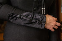 Featuring a cheeky fringe, timeless arrow design across the bust, pleather yoke accents, and elegant faux velvet panels, the black Loretta Dress combines Western-inspired design with contemporary fashion, all handmade from premium bengaline fabric for a flattering, comfortable, and striking silhouette.