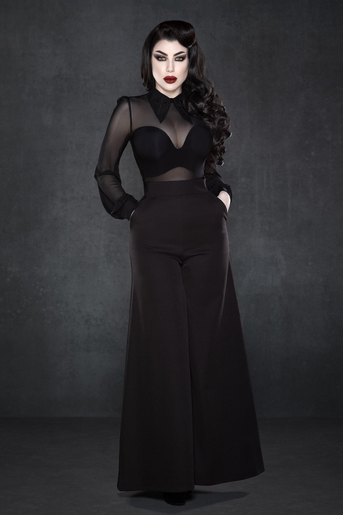 Black wide-leg Palazzo pants with a high-rise waist and chic 1940s-inspired design, made from lightweight crepe fabric with minimal stretch, featuring practical front pockets and a flowing silhouette, perfect for dressing up with heels or pairing with casual tops for a stylish day-to-night look.