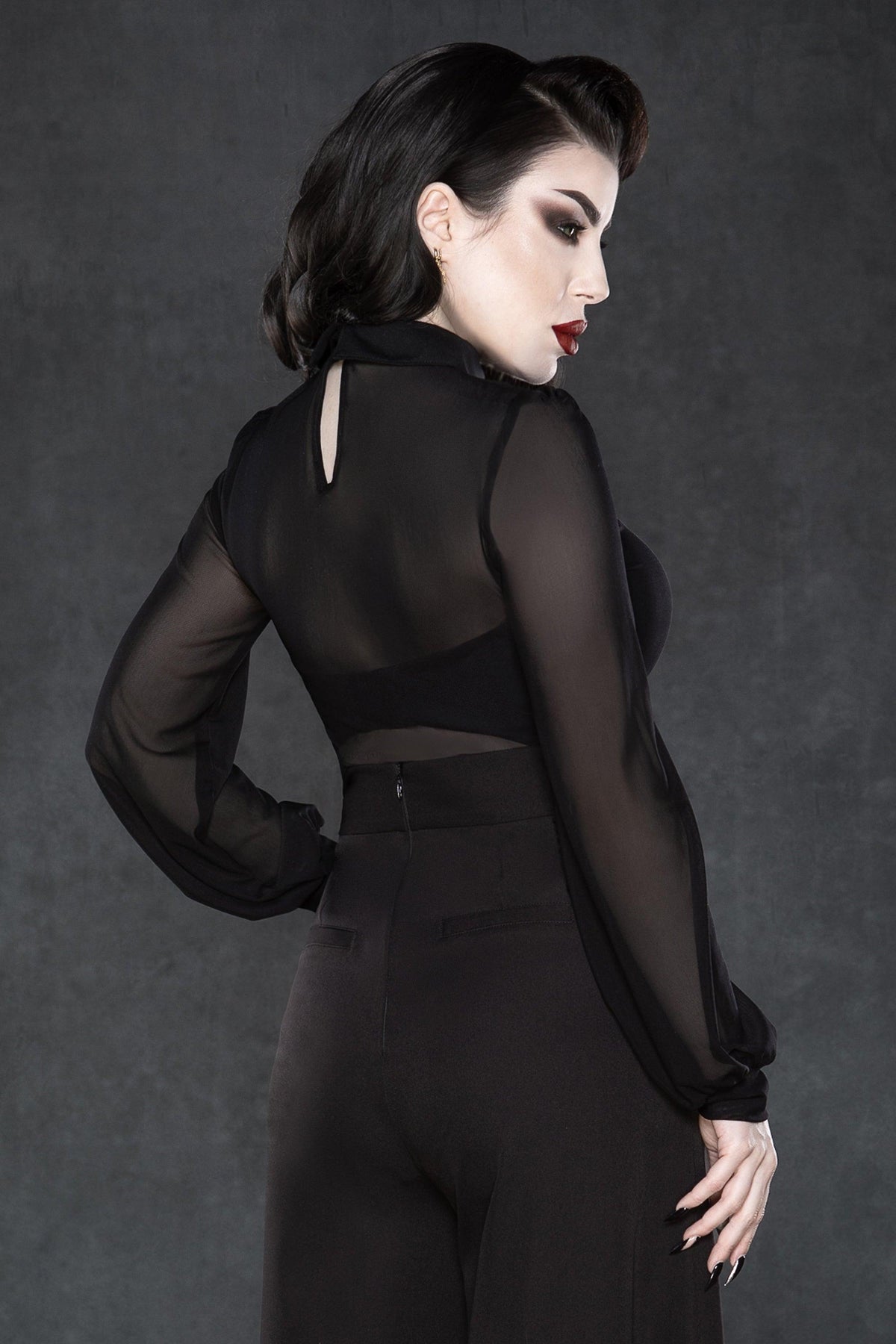 Long-sleeve semi-transparent mesh top with oversized embroidered cross patches on a striking extended pointy collar, soft stretchy material for movement, subtle back keyhole cut-out, and available in black, white, or electric purple, ideal for festival wear, gothic street style, and edgy club outfits.