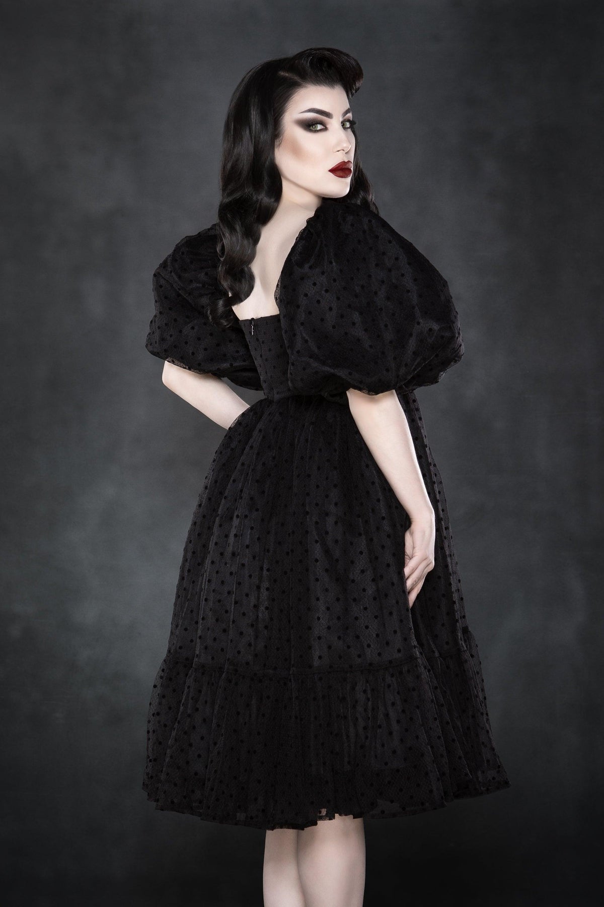 An ethereal, layered polka-dot dress featuring soft chiffon fabric for ultimate volume and movement. The empire waist and square neckline highlight the figure, while the ¾ puff sleeves enhance the dress’s romantic and classic aesthetic. This fully lined, knee-length dress combines gothic sweetness with timeless charm, making it perfect for spring picnics, date nights, or cottagecore-inspired outfits. Crafted from high-quality chiffon and bengaline materials.