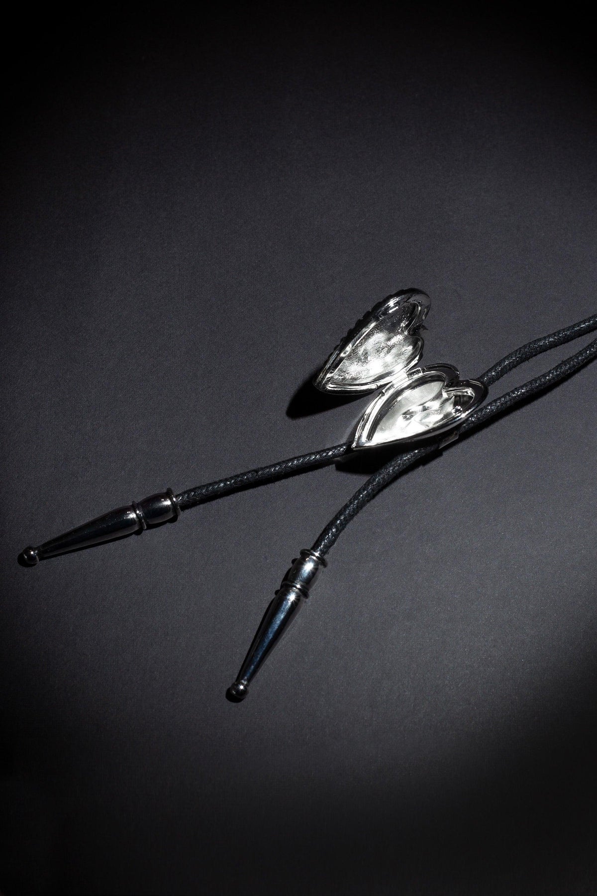 Unique artisan bolo tie with two customizable photo lockets, detailed brand logo etching, and premium craftsmanship, inspired by traditional Western fashion and created for individuals who appreciate bespoke accessories with emotional significance.