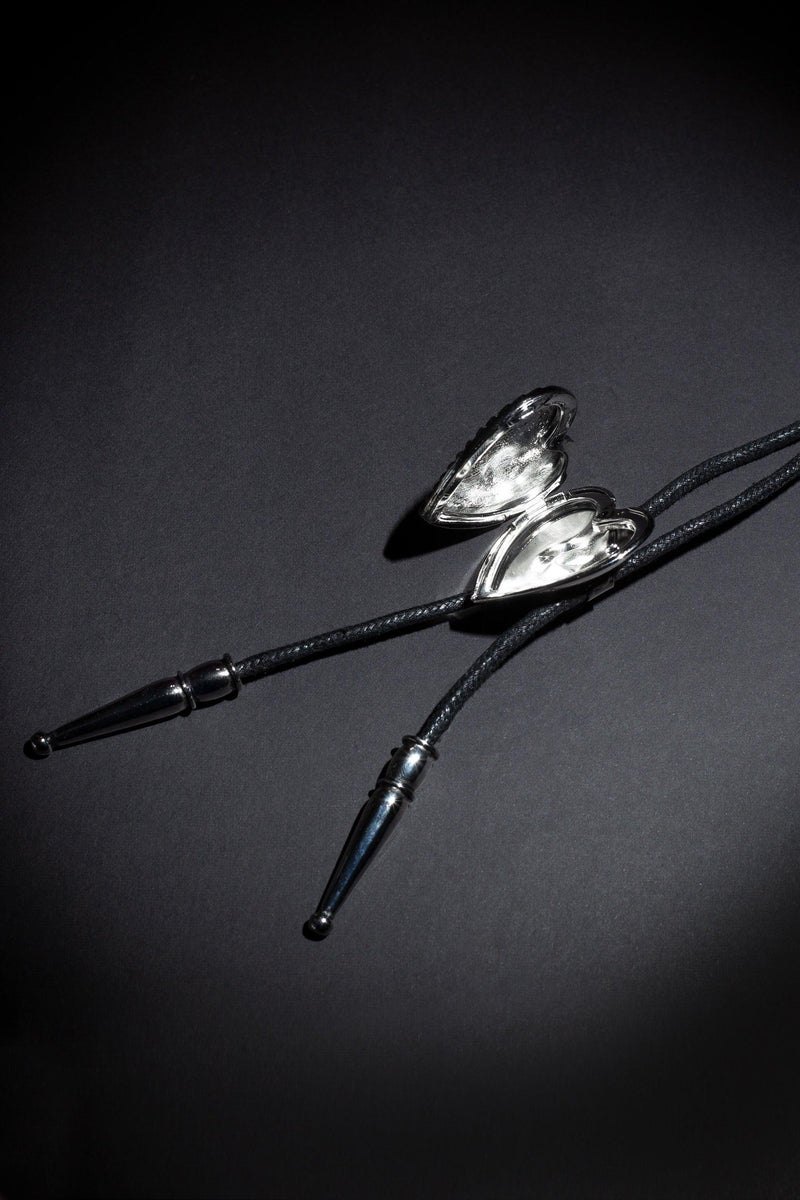 Unique artisan bolo tie with two customizable photo lockets, detailed brand logo etching, and premium craftsmanship, inspired by traditional Western fashion and created for individuals who appreciate bespoke accessories with emotional significance.